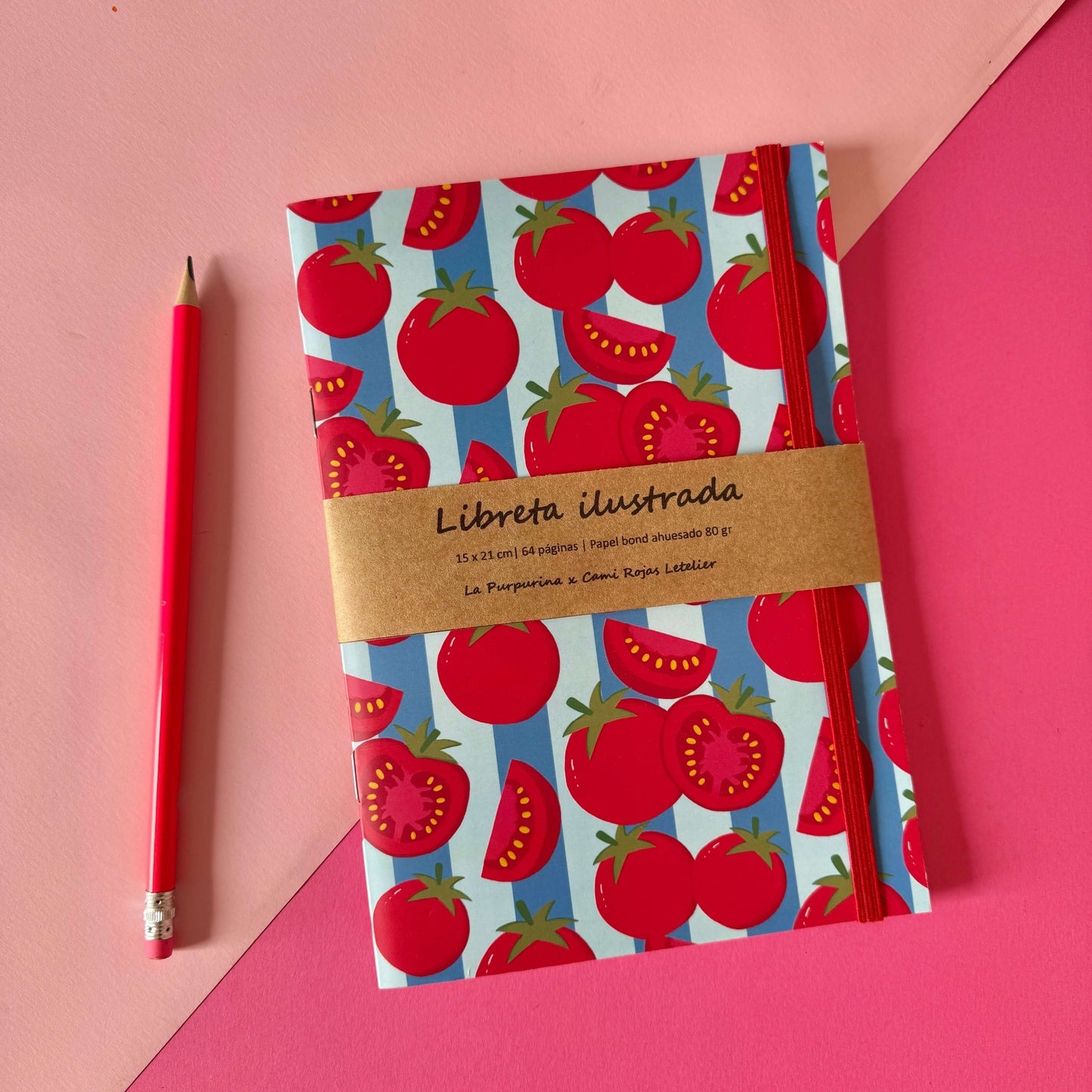 Libreta Frutalia Tomates con diseño de tomates rojos sobre fondo azul y una lápiz cerca. Ideal para notas y journaling.